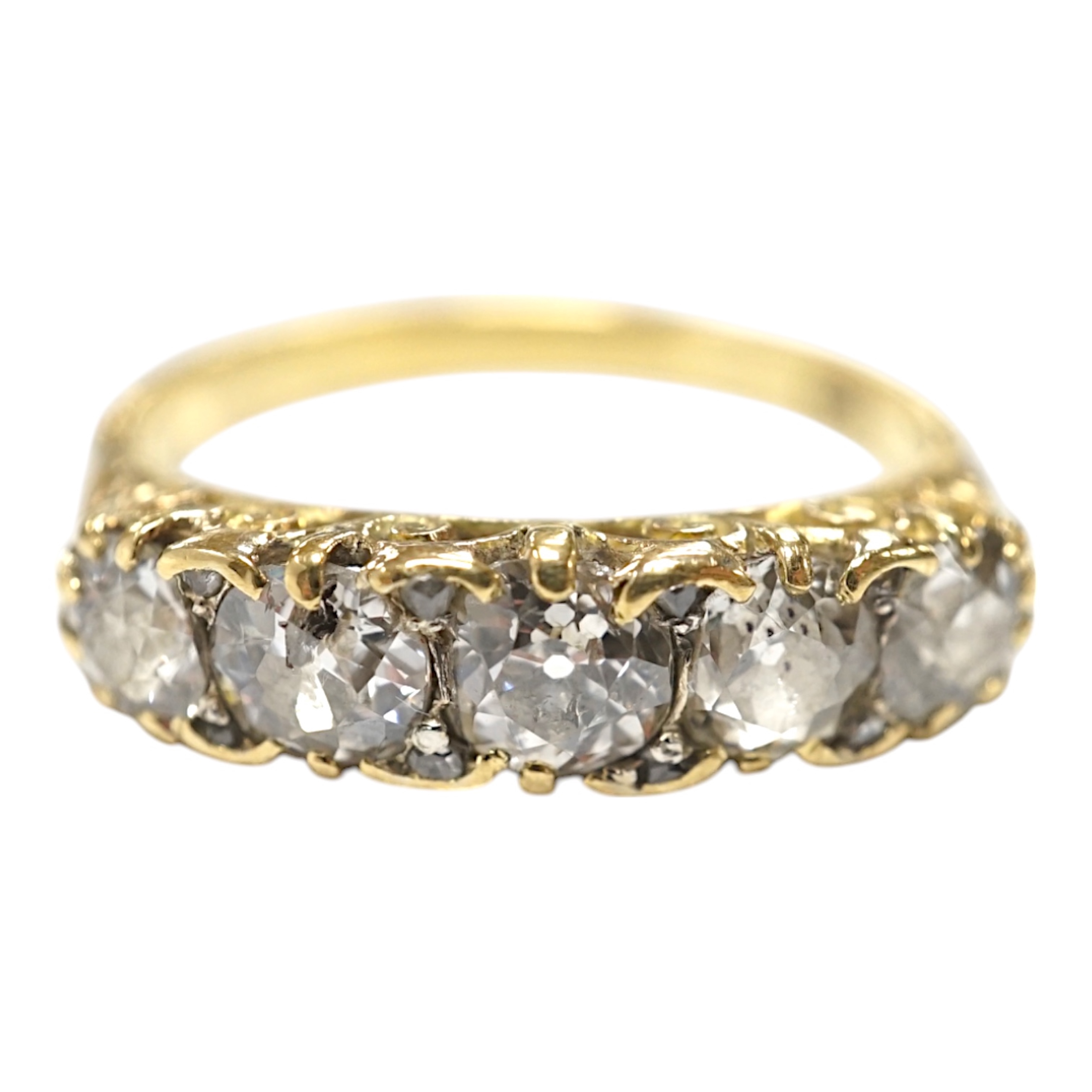 An early 20th century 18ct and graduated five stone diamond set half hoop ring, with rose cut diamond set spacers, size Q/R, gross weight 4 grams. Condition - poor to fair